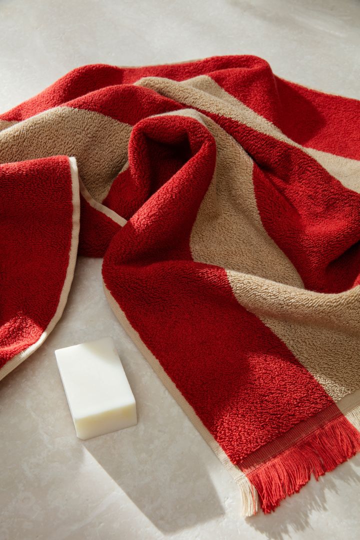 Red accents are one of the Scandinavian interior design trends for 2023, seen here on a cosy towel from Ferm Living. 