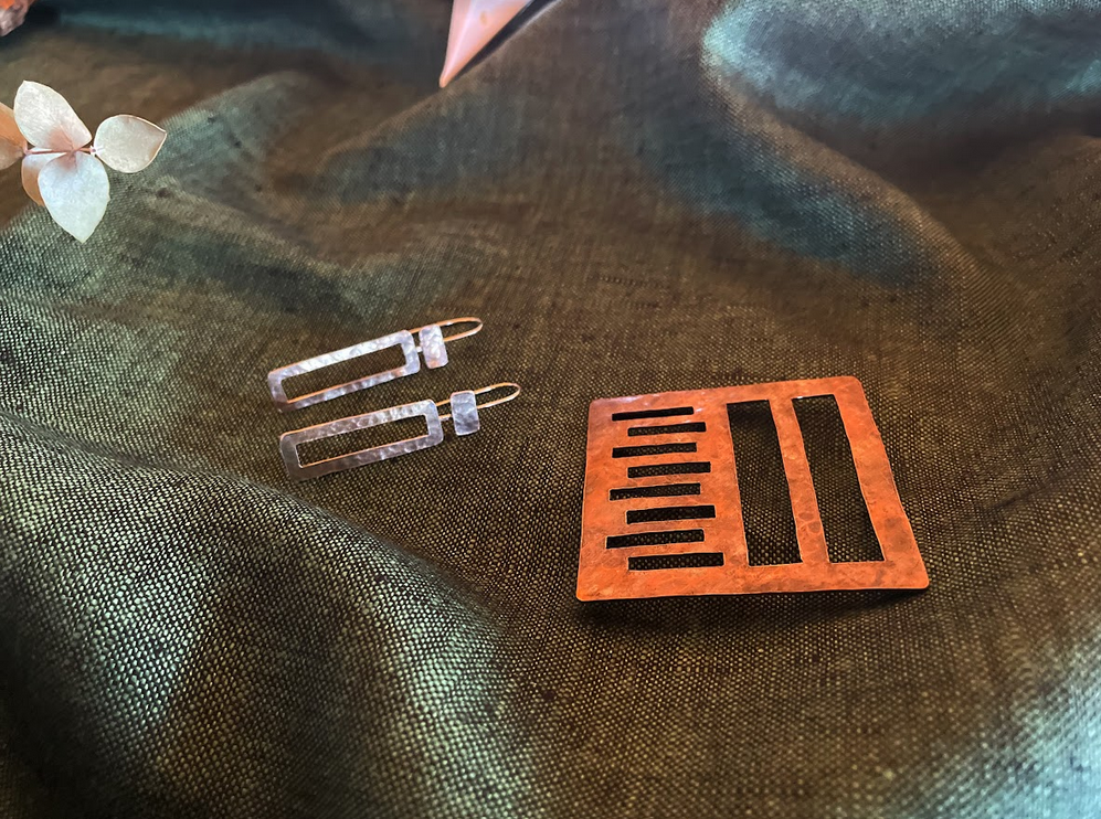 Set of silver earrings and a copper-colored broach pin inspired by window designs at Taliesin. Recommended in the 2021 Gift Guide.